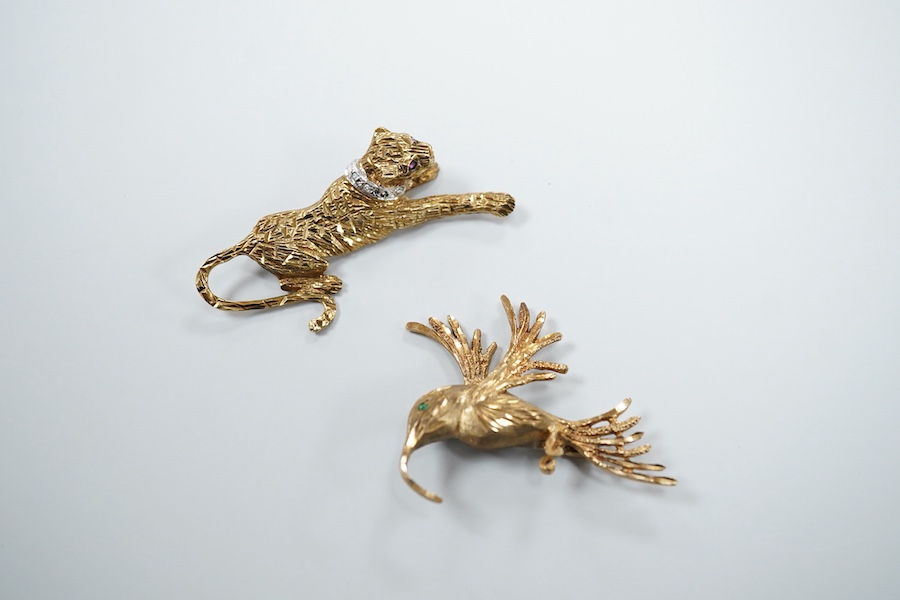 Two 9ct gold brooches, one designed as a collared leopard, its eyes set with rubies, length 5.2cm; the other designed as a hummingbird in flight, its eye set with an emerald, length 4.9cm, each in textured 9ct gold, Brit